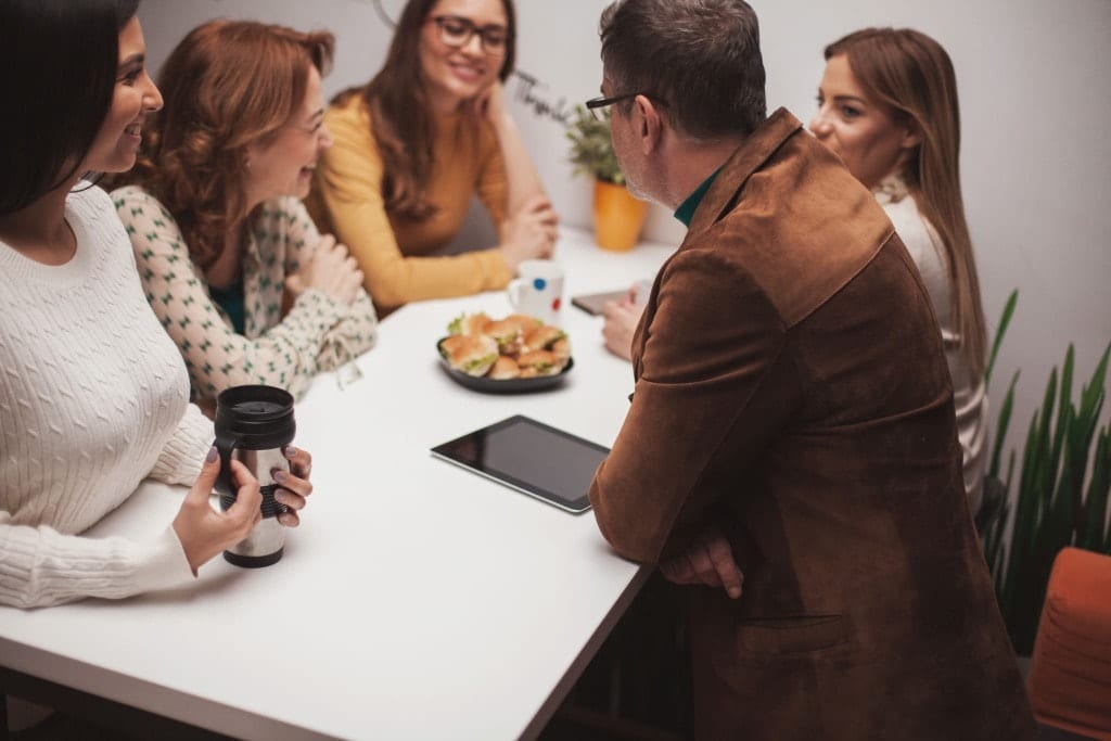 AllCity team sharing a relaxed conversation around a table